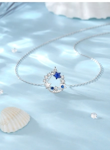 Macro detail of S925 sterling silver starry sky pendant with blue stones and seashell