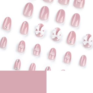 Faux ongles rose avec nœuds blancs 3D, motifs de cœur et détails de perles