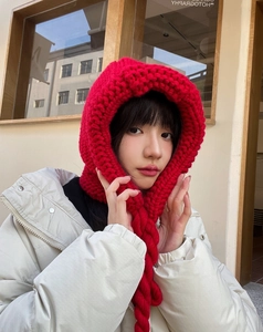Détail d'une cagoule rouge en maille épaisse avec écharpe intégrée pour l'hiver