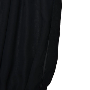 Close-up of black chiffon fabric showing detailed texture and side stitching seams
