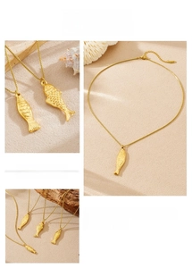 Detailed view of golden fish pendant with intricate scale texture on a dainty box chain