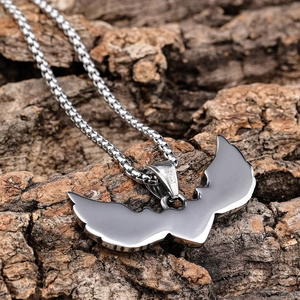 Vintage gothic wing heart pendant in stainless steel on natural bark texture