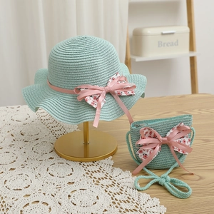 Détail d'un ensemble chapeau et sac en paille vert menthe avec nœuds floraux