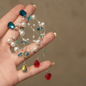 Detailed macro view of multi-layer rainbow crystal pendant with pearls and colorful gems