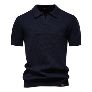 Detailed macro view of navy blue pineapple mesh knit texture on a men's polo shirt