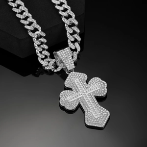 Macro shot of sparkling silver iced out hip hop cross pendant on a Cuban chain necklace