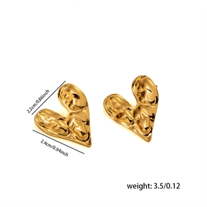 Detailed view of gold heart stud earrings featuring unique hammered texture and dimensions