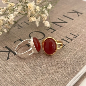 Anello vintage in argento 925 con agata rossa in finiture oro e argento su un libro