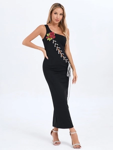 Détail de broderie rose rouge et laçage sur une robe longue noire à une seule épaule