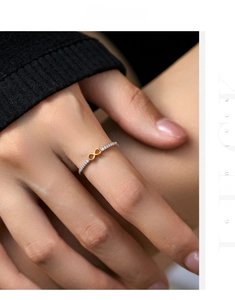 Detailed view of s925 silver ring featuring a golden infinity symbol and pavé accents