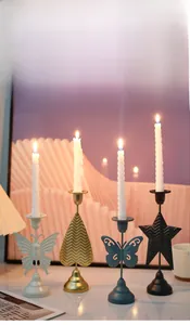 Detailed view of metal candle holders with butterfly, heart, and star shaped ornaments