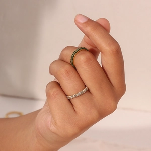 Close-up of gold double row eternity rings with green and white zircon gemstones