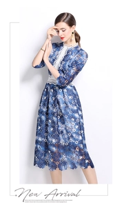 Detail view of blue floral lace dress with intricate white hollowed embroidery
