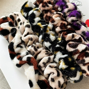 Macro shot of 5-piece set leopard print velvet scrunchies on white packaging card