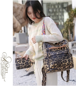 Detail of leopard print backpack set with colorful strap and matching clutch on a model