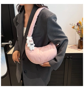 Détail du sac croissant matelassé rose clair avec un pendentif lapin blanc