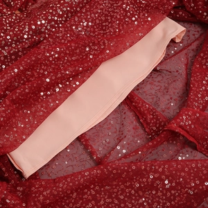 Detail of red sequins on mesh fabric with silky lining for heavy luxury party dress