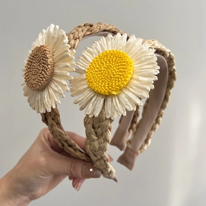 Handwoven raffia sunflower headbands with large daisy embellishments in two colors