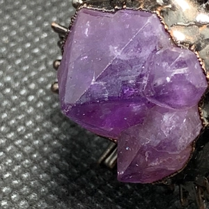 Macro close-up of natural purple amethyst crystal on vintage bronze adjustable ring