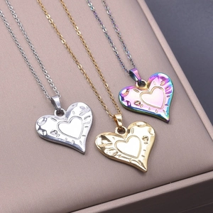 Detailed view of heart-shaped pendants in gold, silver, and iridescent finishes on box
