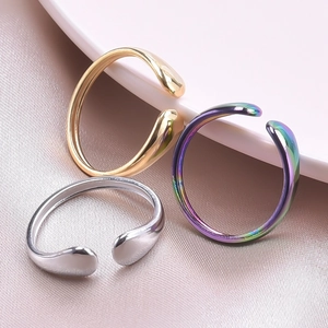 Macro shot of minimalist open rings in gold, silver and aurora finish on silk texture