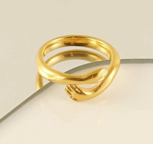 Detailed close-up of a high-polished golden hugging hands ring on a silk ribbon