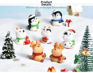 Miniature Christmas animal figurines featuring penguin and reindeer on snow background