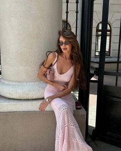 Detail of pink crochet knit maxi dress featuring intricate geometric cut-outs and V-neckline