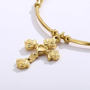 Elegant gold titanium cross bangle featuring rose flower patterns and a heart detail