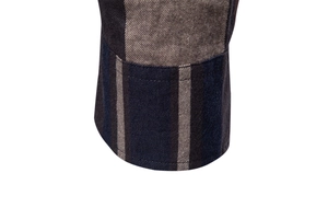 Détail du poignet d'une chemise tissée à carreaux montrant des motifs rayés bleu et marron