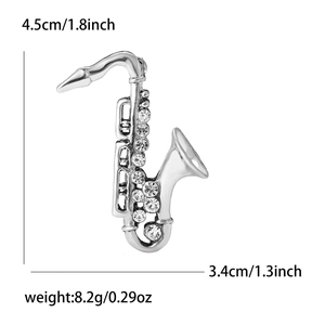 Detail view of silver saxophone brooch with rhinestones including size and weight specs