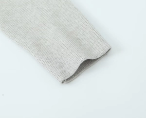 Close-up of the light gray knit cardigan sleeve with fine ribbing detail and soft texture