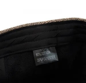 Detail view of the inner black lining and care label of a striped newsboy cap