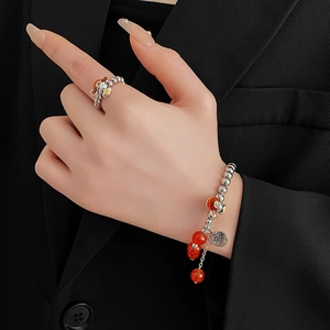 Detailed view of silver dragon pearl bracelet and ring set with traditional charms