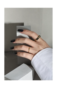 Detailansicht eines minimalistischen Goldrings mit Wassertropfen und strukturiertem Band