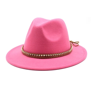 Detail of rose pink fedora hat with woven brown band and golden beads on wool felt