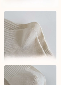 Detail of cream rib-knit mid-calf socks showing elastic cuffs and reinforced heels