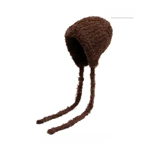 Detail of coffee brown plush faux fur earflap hat with long decorative knit straps
