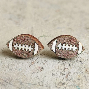Macro di orecchini a perno in legno a forma di football americano con trama marrone e cuciture