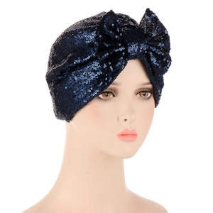 Detailed view of deep blue sequins and a large bow on the women's turban hat