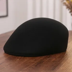 Classic black wool newsboy cap for women on a textured wooden background