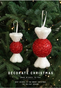 Detail of red and white Christmas candy ornaments with glitter hanging on a festive tree