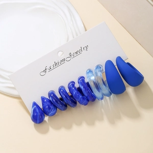 Detail of Klein blue earring set featuring water drop and C-shape hoop designs