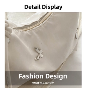Detail view of cream leather tote bag featuring a silver butterfly hardware and metal zipper