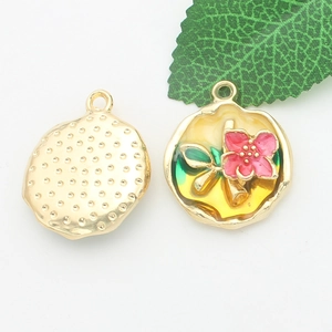 Detail showing enamel flower charms with pink petals and gold back for DIY jewelry