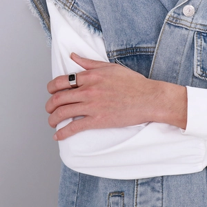 Close-up of a men's vintage silver ring featuring a square black gemstone inlay on hand
