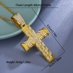 Macro view of gold iced out cross pendant with rope chain on a light blue display tray