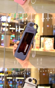 Close-up of portable flat water bottle with frosted protective case and woven lanyard