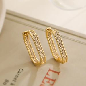 Chic gold plated rectangular geometric earrings with pave set zircon on a magazine