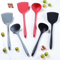 Set di spatole e cucchiai in silicone colorato su sfondo di marmo bianco pulito